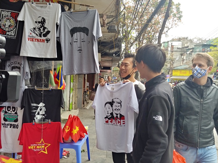 El 24 de febrero, un turista japonés sostiene una camiseta con los retratos del presidente estadounidense Donald Trump y el líder norcoreano Kim Jong Un en una tienda en la calle Hang Bong en Hanói, Vietnam.